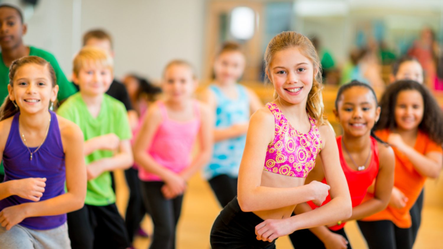 A diverse group of children participating in a dance fitness class.